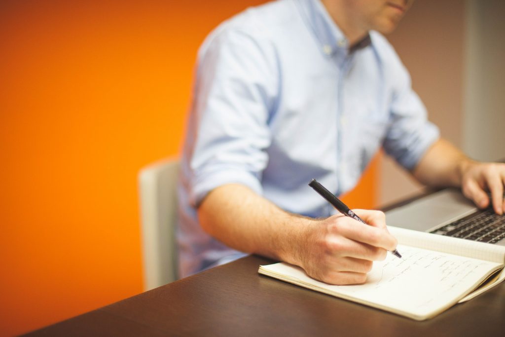 Man with pen at desk | calculate income tax